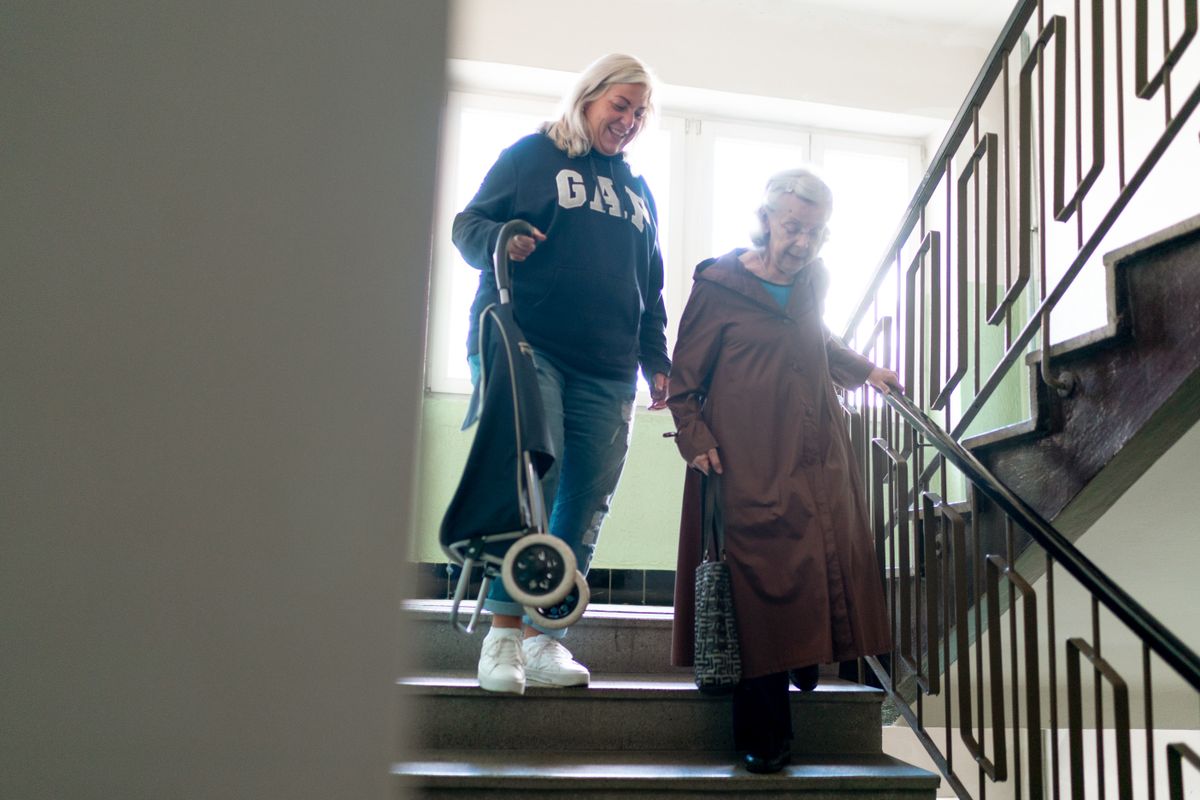 Caregiver helping an elderly person with stairs